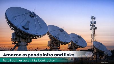 Satellite ground station with multiple parabolic dishes at dusk behind industrial fencing